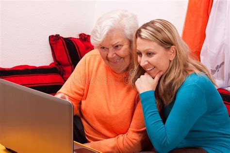 La Jeune Femme Blonde Explique Un Plus Vieux Un Ordinateur Portatif Photo Stock Image Du
