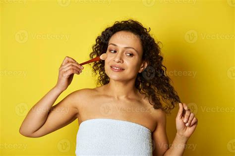 Charming Half Naked Mulatto Woman Holding A Makeup Brush And Applying Blush On Her Face