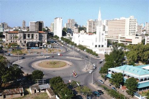 An Aerial View Of A City With Tall Buildings And Cars Driving On The