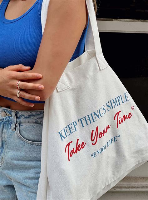 A Woman Holding A White Bag That Says Keep Things Simple Take Your Time