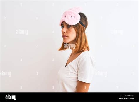 Beautiful Redhead Woman Wearing Sleeping Mask Over Isolated Background