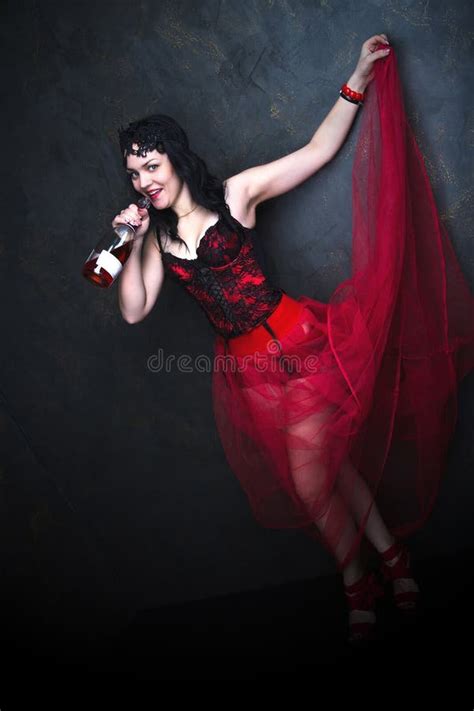 Happy Beautiful Brunette Woman In Corset And Long Hair With Bottle Of Red Wine Stock Image