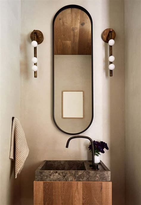 A Bathroom Sink Sitting Under A Mirror Next To A Wall Mounted Faucet