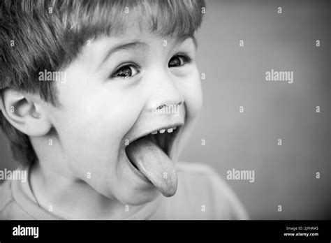 Kids funny face. Close up portrait of a cute little child show tongue ...