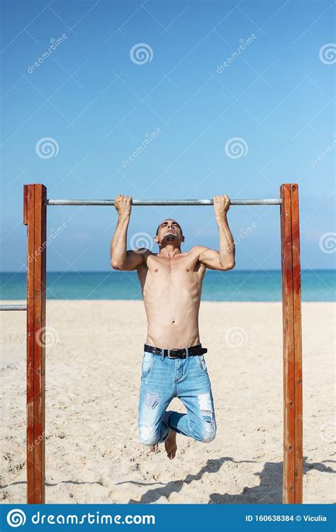 A Male Athlete With A Naked Torso Is Training On A Horizontal Bar Stock Photo Image Of Beach