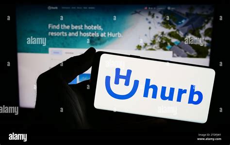 Hurb Technologies S.a - Person holding smartphone with logo of Brazilian travel company Hurb ...