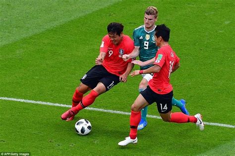 Two Soccer Players Are Fighting For The Ball In Front Of Another Player