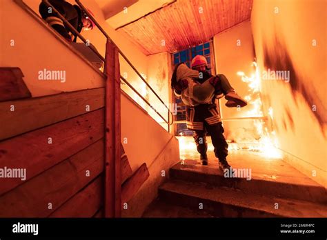 Brave Fireman Descends Stairs Of A Burning Building And Holds Saved