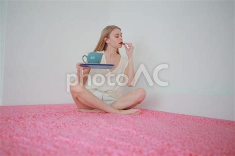 ベッドでお菓子を食べる女性 No 1032882｜写真素材なら「写真ac」無料（フリー）ダウンロードok