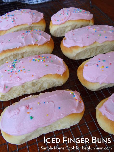 iced finger buns with pink frosting and sprinkles on a cooling rack