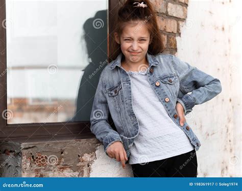 Portrait Of A Beautiful Teenage Girl Posing Against A Brick Wall And