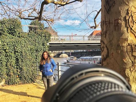 Premium Photo Woman Standing By River Against Bridge