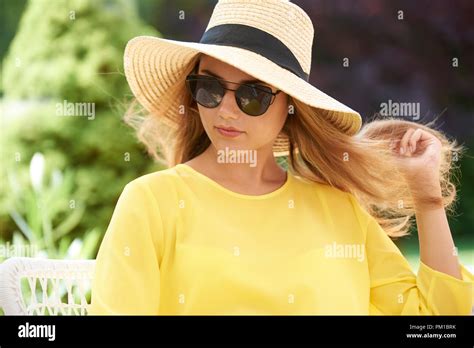 Headshot Of Confident Young Woman Wearing Straw Hat And Sunglasses