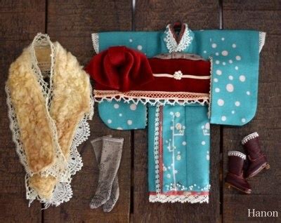 An Old Doll S Clothes And Accessories Are Laid Out On A Wooden Table Top