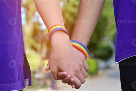 pulsera arcoíris que lleva en la mano un joven gay asiático para mostrar y representar la