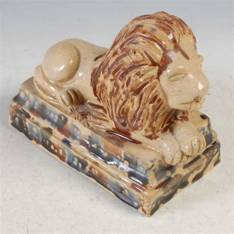 Lot 331 - An Antique pottery model of a recumbant lion