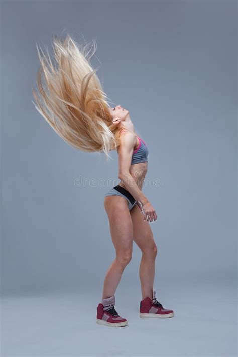 Athletic Blonde Girl Tossed Her Long Hair On Grey Background Stock