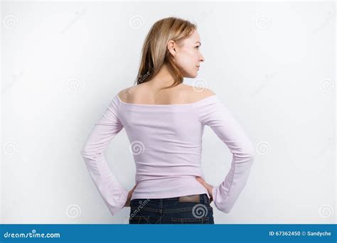 La Bella Giovane Bionda Con Le Gambe Lunghe In Una Blusa Luminosa Con Le Spalle Nude Girate A