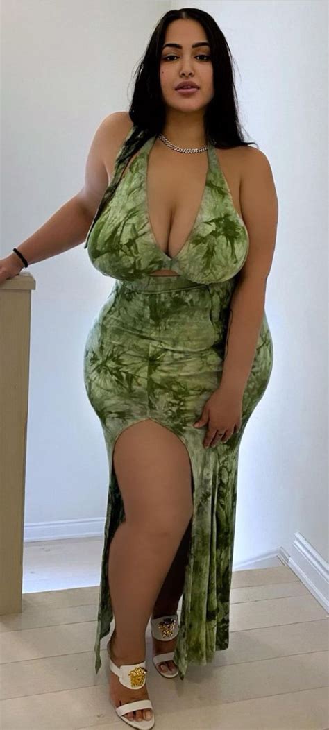 A Woman In A Green Dress Posing For The Camera