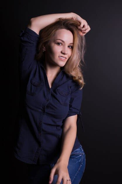 Belle Jeune Femme Blonde Aux Longs Cheveux Bouclés Porte Des Vêtements à La Mode Posant Sur Un