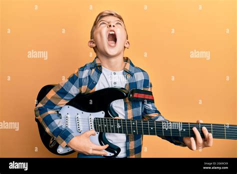 Little Caucasian Boy Kid Playing Electric Guitar Angry And Mad