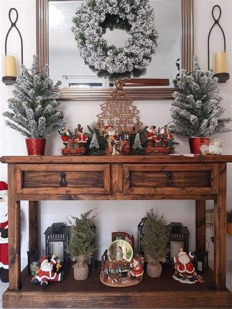 A Wooden Table Topped With Potted Plants Next To A Christmas Wreath On