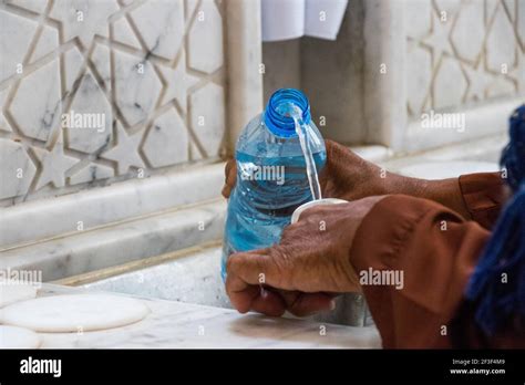 Filling zamzam water into the bottle. Zamzam well in Masjid-Haram ...