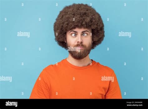 Portrait of crazy funny man with Afro hairstyle wearing orange T-shirt ...