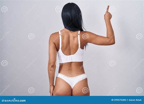 Hispanic Woman Wearing Lingerie Posing Backwards Pointing Ahead With