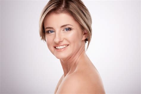 Premium Photo Smiling Woman In Average Age With Nude Make Up And Naked Shoulders Posing Wall