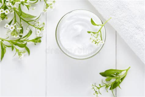 Natural Cosmetic Product In Bottle With Herbs And Flowers On Pink