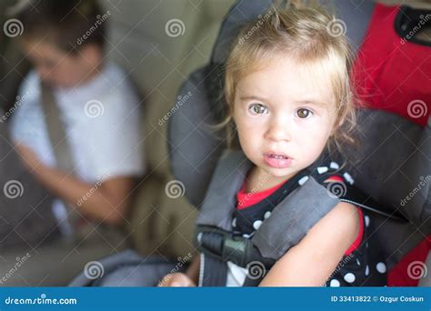 Petite Fille Attachée Dans Un Siège De Sécurité De Childs Photo stock