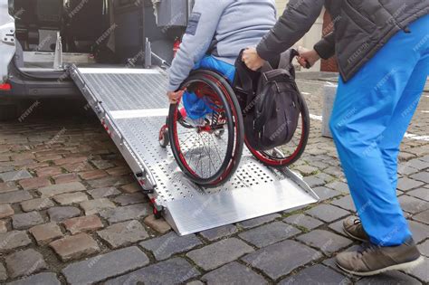 Premium Photo | Person on wheelchair using accessible car ramp