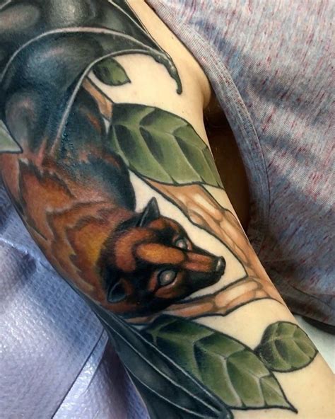 a man with a tattoo on his arm has a fox and leaves design on it