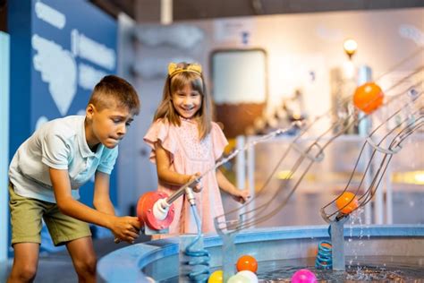 Menino e menina brincando em um museu de ciências Foto Premium