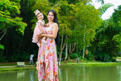 Retrato De Una Mujer Latina Sosteniendo A Su Peque O Beb Moreno En Sus Brazos Mientras Paseaba