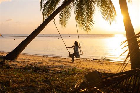 The Girl On The Beach Rides On A Swing During Sunset Sunset In The