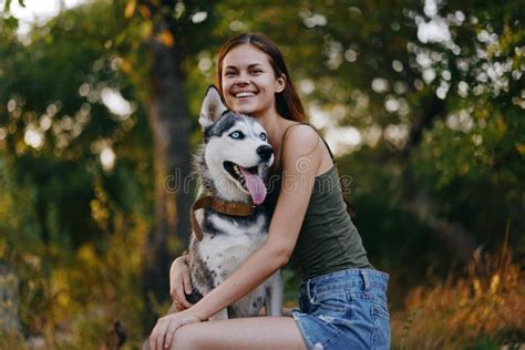 Femme Joyeuse Avec Un Chien De Race Husky Souriant En Pleine Nature Sur