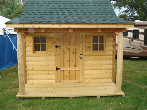 a small wooden shed sitting on top of a lush green field