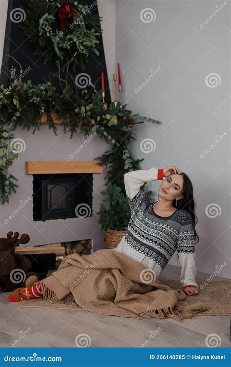 Beautiful Pregnant Woman Sitting By The Fireplace Wrapped In A Brown