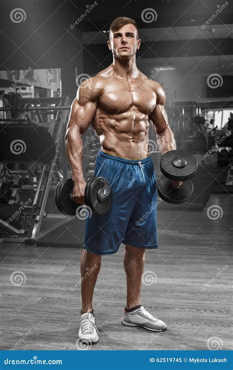 Muscular Man Working Out In Gym Doing Exercises With Barbell Strong