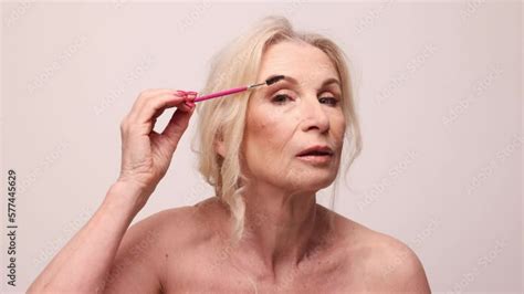 Beautiful Middle Aged Woman With Well Kept Healthy Skin Nude Makeup Brushing Eyebrows Agaisnt