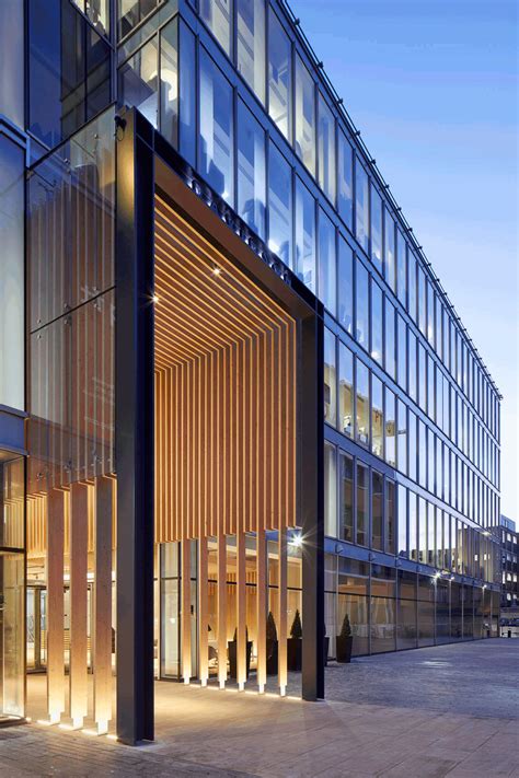 The Entrance To An Office Building Lit Up At Night With Lights Shining