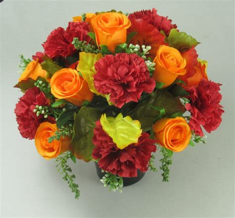 Grave flower arrangement with red large carnations and orange rose buds ...