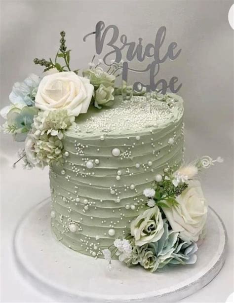 A Green Wedding Cake With White Flowers On Top