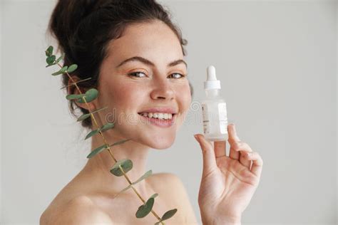 Half Naked Brunette Woman Showing Face Serum And Eucalyptus Stock Photo