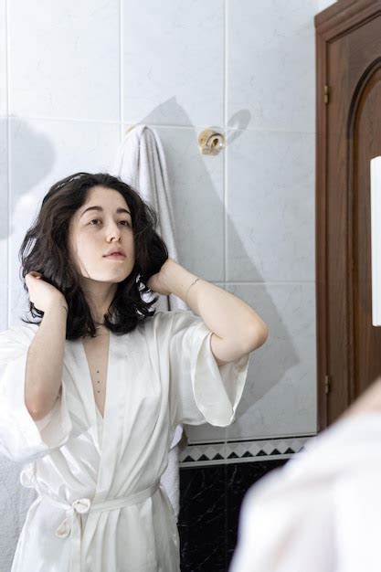 Mulher Latina No Banheiro Jovem Mulher Brincando O Cabelo Na Frente De Um Espelho Foto Premium