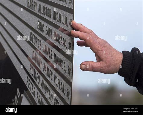 A Hand Touches The Monument That Honours The 26 Coal Miners Who