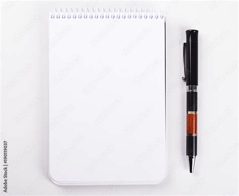 Notepad With Blank Paper Next To Black Pen On White Background