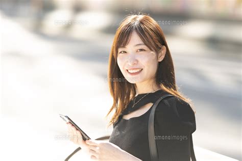 ベンチに座ってスマホを見ている女性の写真素材 Fyi07787202 ストックフォトの Qlean Market